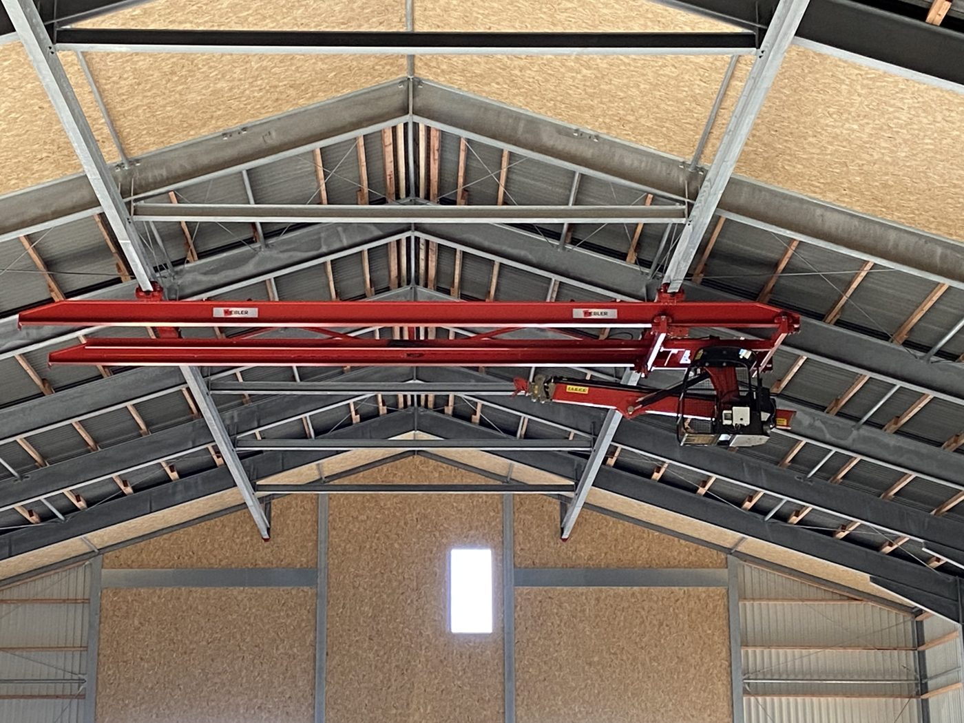 Heukran unter dem First einer 59 × 27 m Heutrocknungshalle in Jüchen – die Kranbahn ist in der Statik von Anfang an eingeplant.