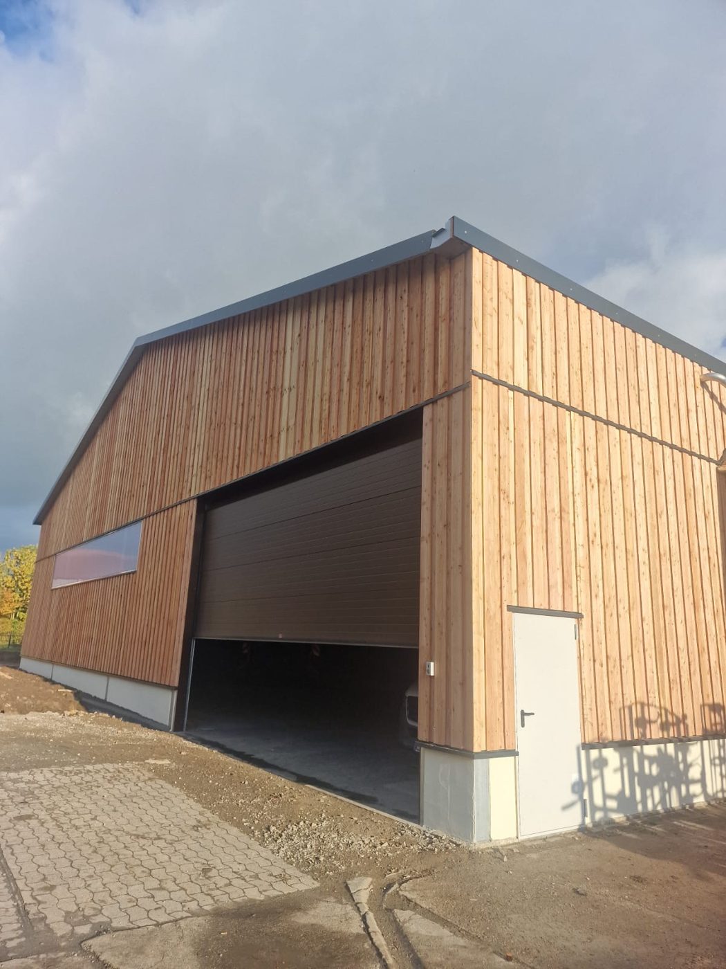 Holz-Boden-Deckel-Schalung an einer Maschinenhalle in Niedersachsen – gebaut, weil sich die Halle ins Ortsbild einfügen sollte.