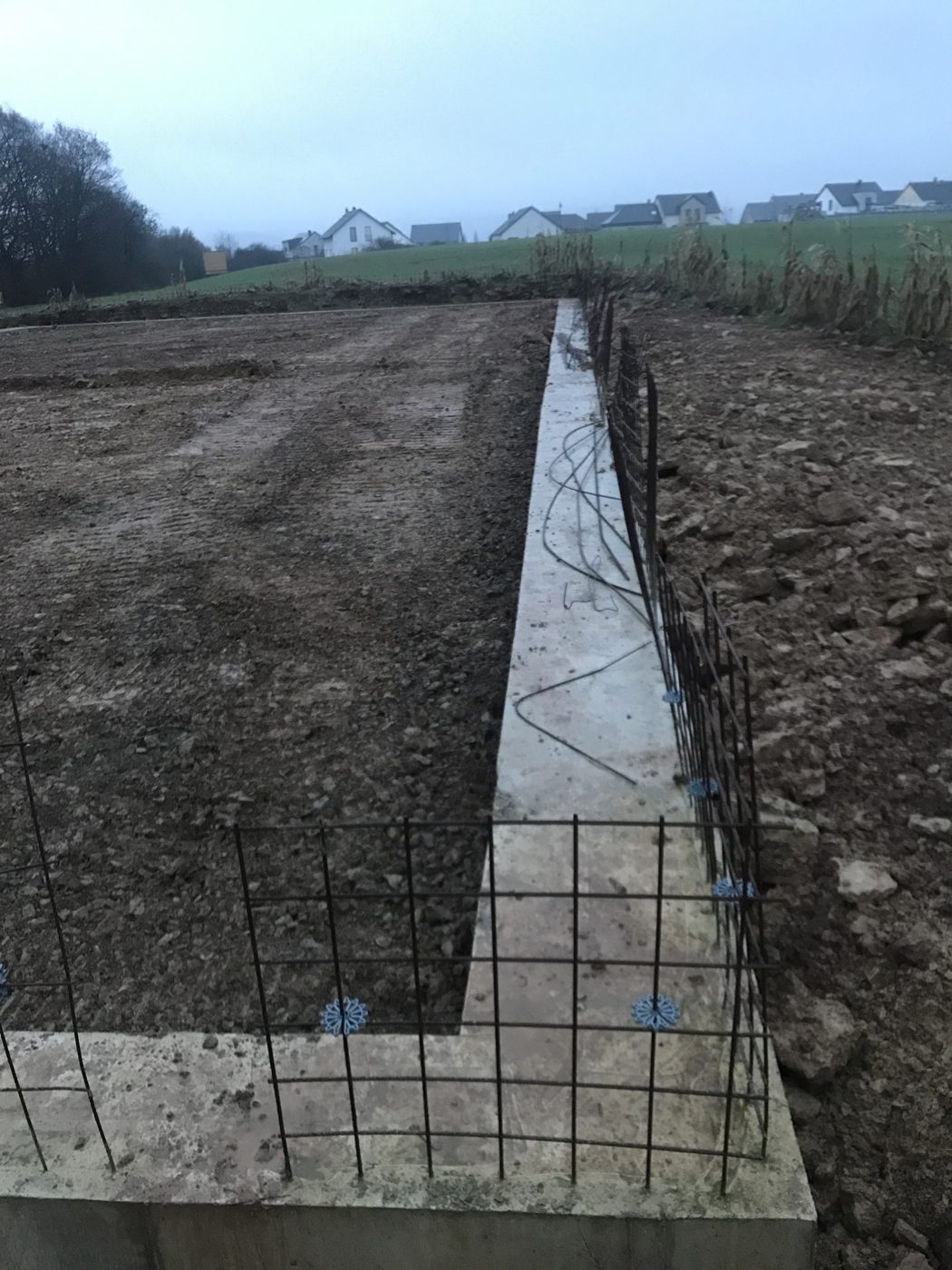 Bewehrtes Streifenfundament vor dem Betonieren an einer 36 × 20 m Maschinenhalle in der Eifel.
